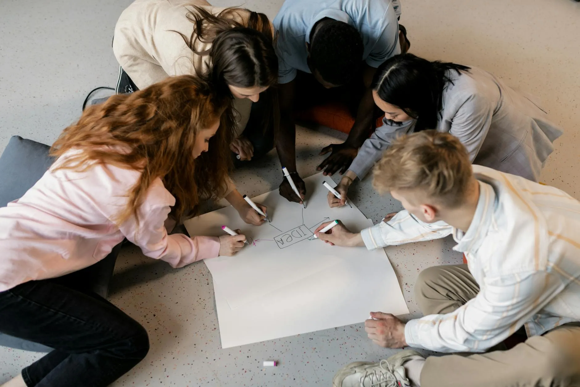 Équipe associative collaborant autour d’un brainstorming au sol