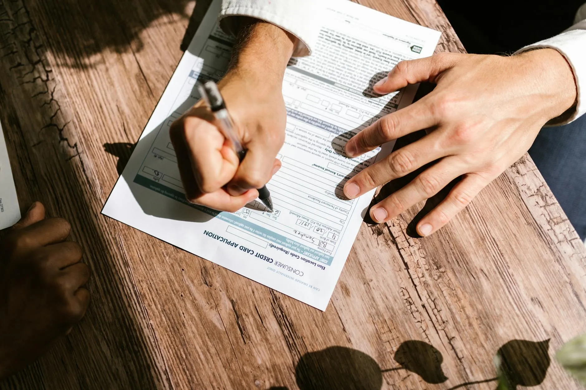 Dossier de candidature financement, mains remplissant un formulaire de demande sur un bureau